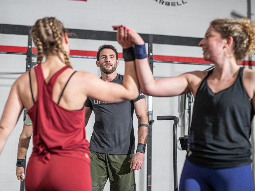 люди в тренировочной группе Crossfit поздравляют себя